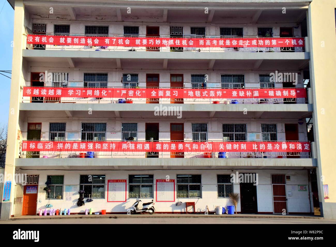 Banner sind auf eine Lehre Gebäude gehängt zu mobilisieren Diplomanden für die bevorstehende jährliche College Aufnahmeprüfung, auch bekannt als Gaokao, Stockfoto