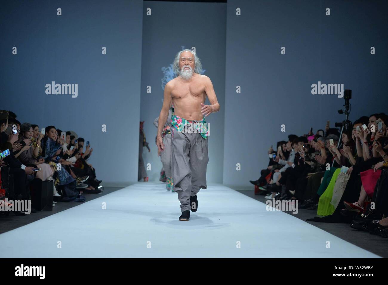 79-jährige chinesische Schauspieler Wang Deshun zeigt eine neue Schöpfung durch Chinesische Mode Designer am Sheguang Sheguang Hu Hu fashion show während der China Stockfoto