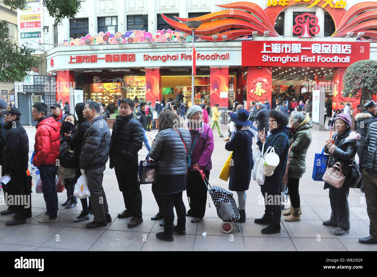 Chinesischen Einwohner Warteschlange auf der Einkaufsstraße Nanjing Road street bereit zu kaufen-zu-kochen Gerichte für die Familienzusammenführung Abendessen für das chinesische Neujahrsfest Ja Stockfoto