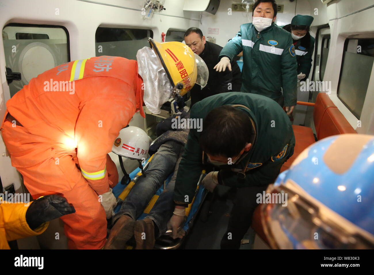 Chinesische Retter, ein Überlebender auf einen Krankenwagen, nachdem er aus Ablagerungen eines Hotels vom Erdrutsch in Bianhe Dorf verwüstet gezogen wurde, Chengguan Stockfoto