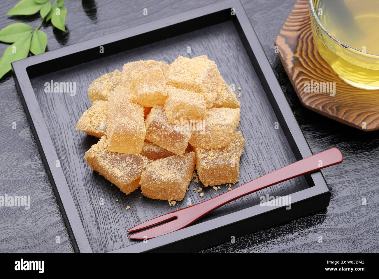 Japanische Süßwaren, Warabi mochi traditionellen Süßigkeiten auf schwarzem Hintergrund Stockfoto