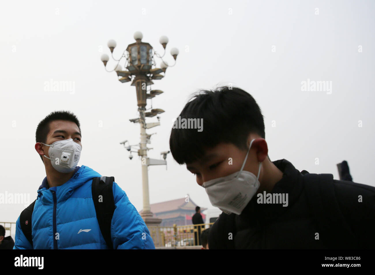 Die Touristen tragen Gesichtsmasken gegen die Verunreinigung der Luft besuchen Sie den Platz des Himmlischen Friedens im heavy Smog in Peking, China, 11. Dezember 2016. Chinas meteorologischen Stockfoto