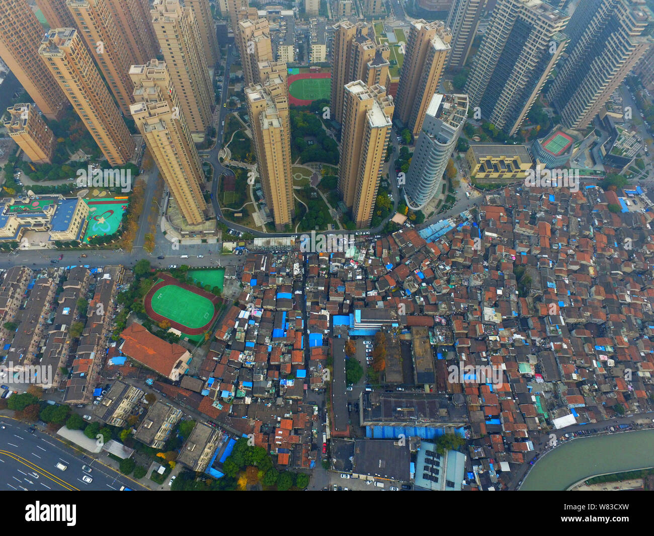 ---- Eine Luftaufnahme einer Barackensiedlung mit alten Häusern neben Cluster von Modern high-rise residential Apartment Gebäude in Shanghai, China, 7 Deze Stockfoto