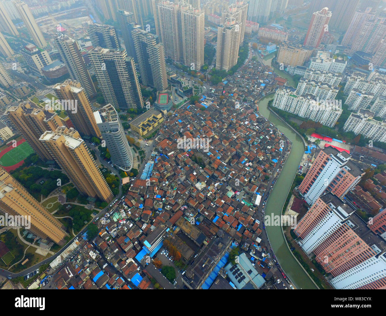 ---- Eine Luftaufnahme einer Barackensiedlung mit alten Häusern neben Cluster von Modern high-rise residential Apartment Gebäude in Shanghai, China, 7 Deze Stockfoto
