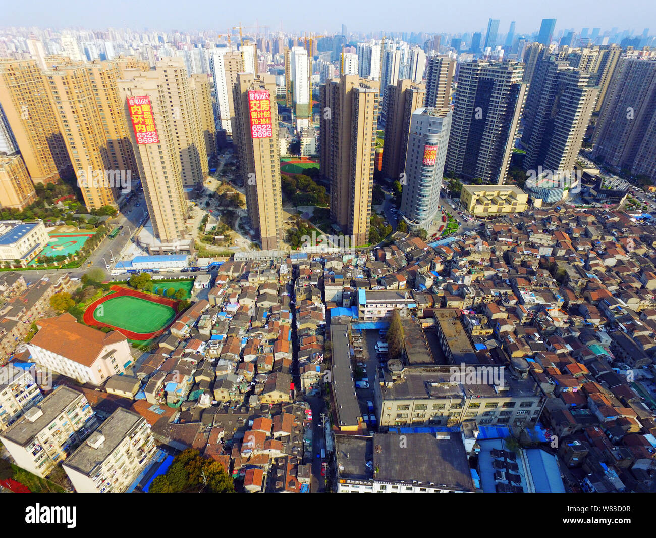 ---- Eine Luftaufnahme einer Barackensiedlung mit alten Häusern neben Cluster von Modern high-rise residential Apartment Gebäude in Shanghai, China, 27. März Stockfoto