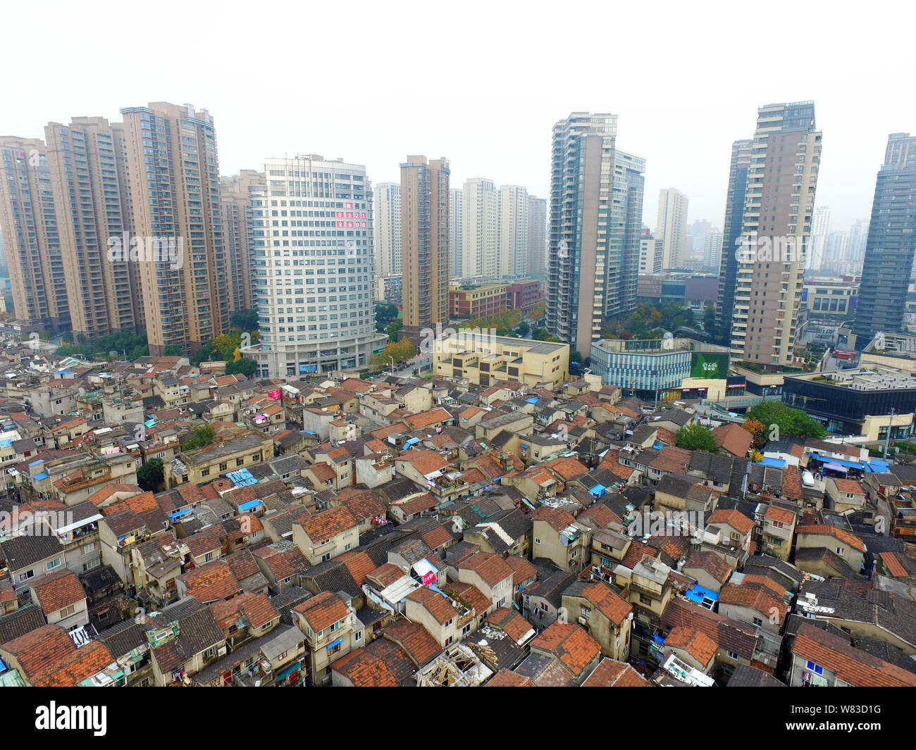 ---- Eine Luftaufnahme einer Barackensiedlung mit alten Häusern neben Cluster von Modern high-rise residential Apartment Gebäude in Shanghai, China, 7 Deze Stockfoto