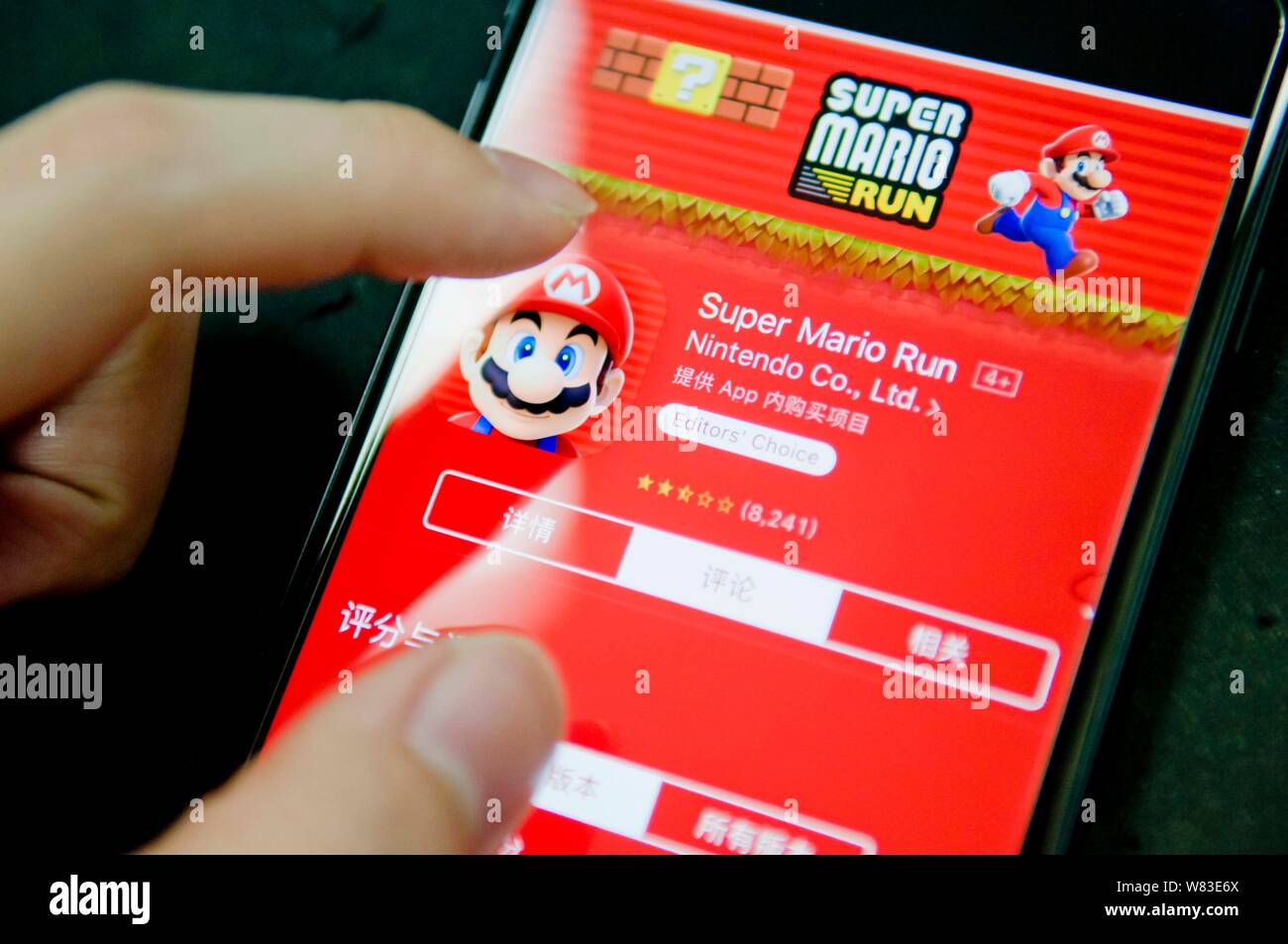 Ein chinesisches Handy Benutzer bereitet die App von Nintendos mobile Spiel Super Mario Ausführen" aus dem Apple App Store auf sein Smartphone in Gua zum Download Stockfoto