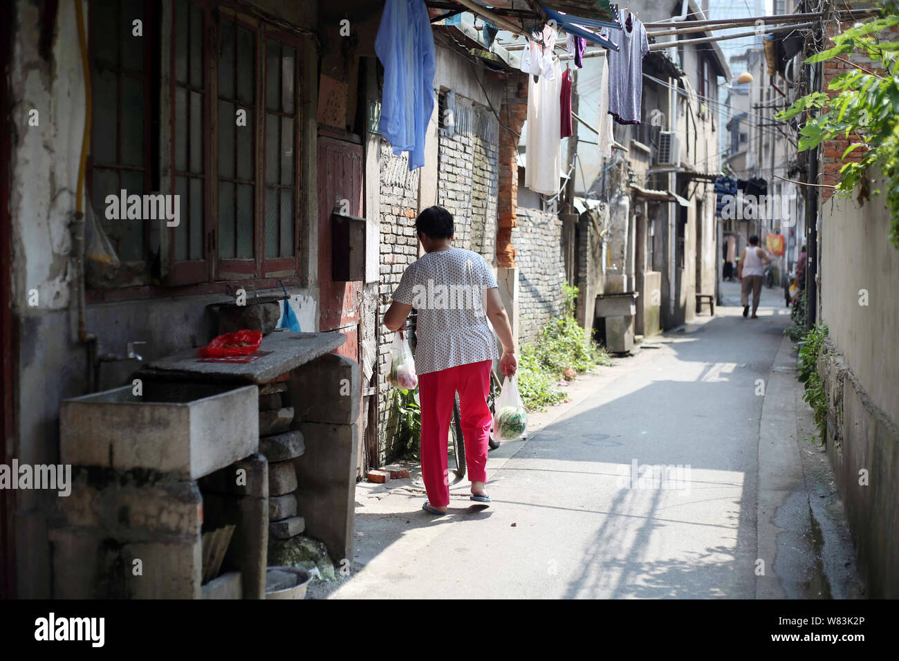 ------ Lokale chinesische Bewohner Spaziergang vorbei an alten Häusern entlang einer Spur zu einer Barackensiedlung für Wiederaufbau in Shanghai, China, 27. Juli 201 demontiert werden Stockfoto