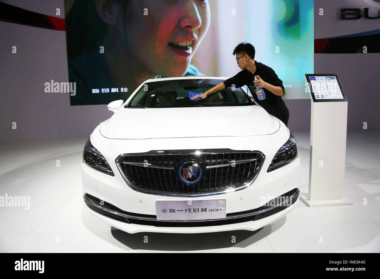 ---- Ein chinesischer Arbeiter Stäube aus einem Buick Lacrosse der SAIC-GM, ein Joint Venture zwischen der SAIC Motor und General Motors, auf dem Display während ein Auto Show Stockfoto