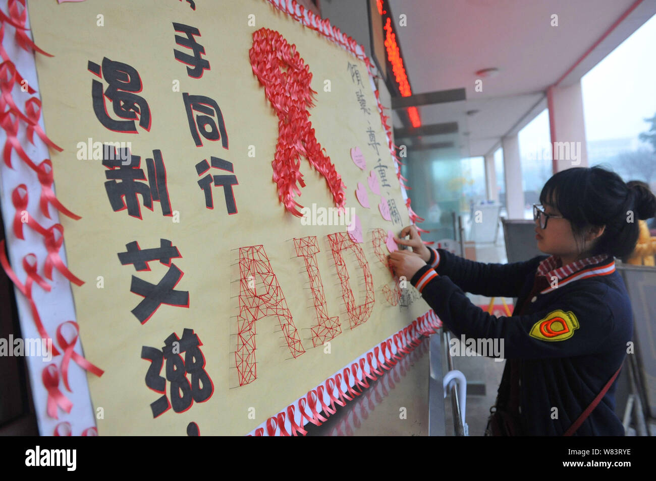 Ein weiblicher chinesischer Student schmückt ein Plakat, Vorbeugung von HIV und AIDS an einer Universität in Hangzhou zu propagieren, der East China Zhejiang provi Stockfoto