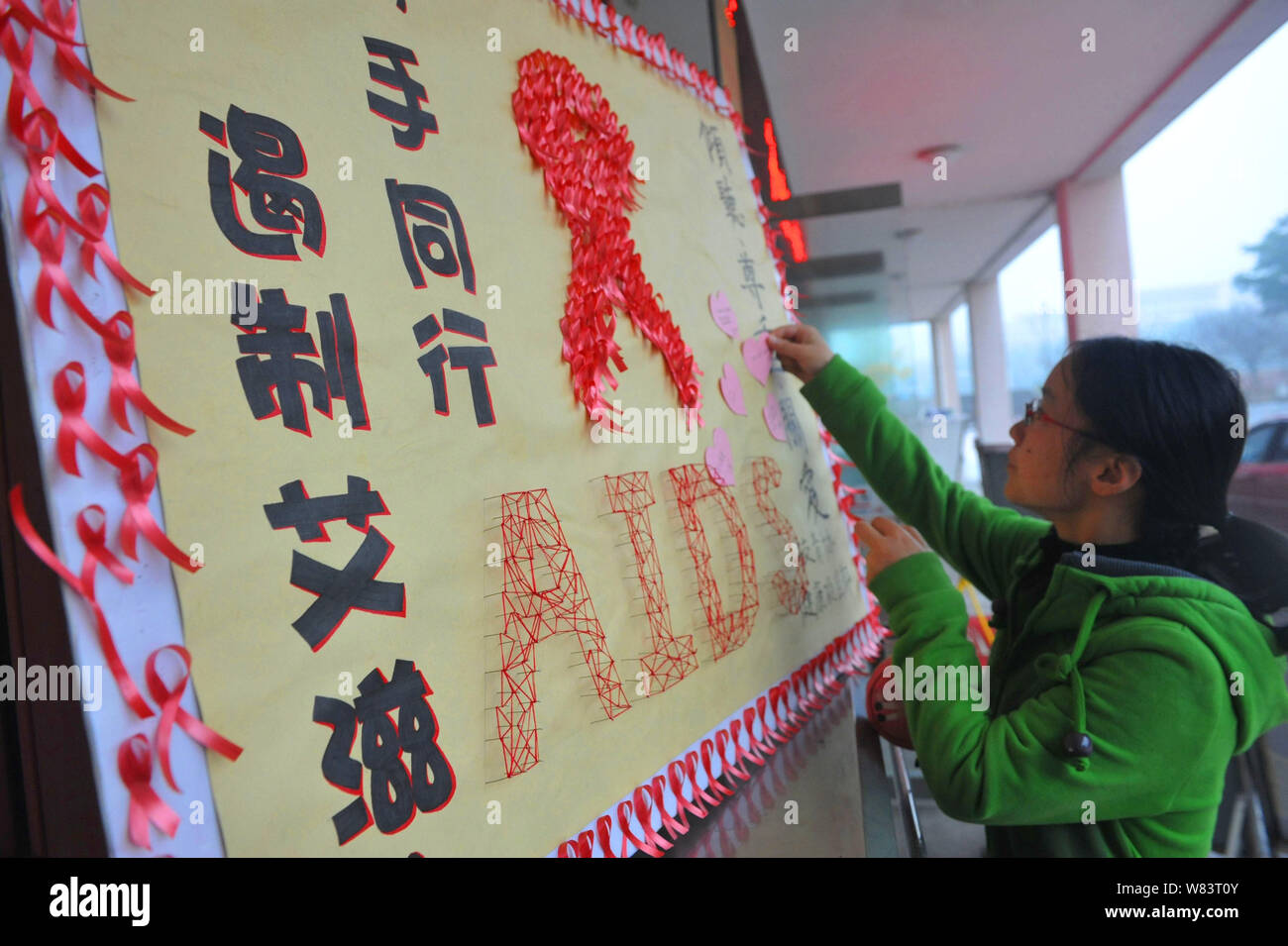 Ein weiblicher chinesischer Student schmückt ein Plakat, Vorbeugung von HIV und AIDS an einer Universität in Hangzhou zu propagieren, der East China Zhejiang provi Stockfoto