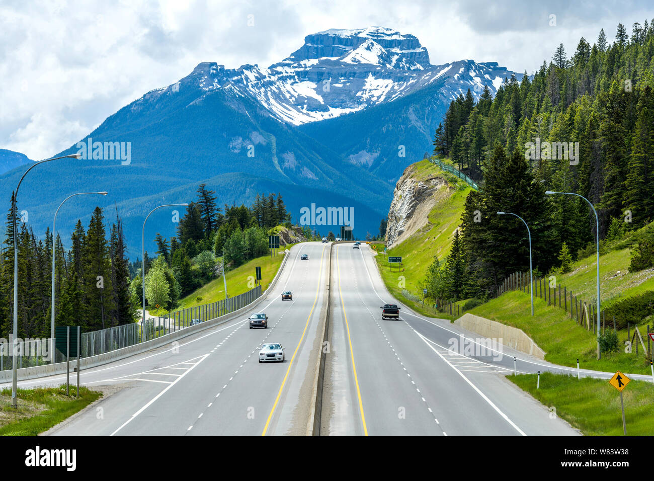 Trans-Canada Highway bei Banff - EINE trübe Frühling Blick auf Trans-Canada Highway die Ausfahrt nach Banff Gebiet, mit Mt. Bourgeau hoch aufragenden im Hintergrund. Stockfoto