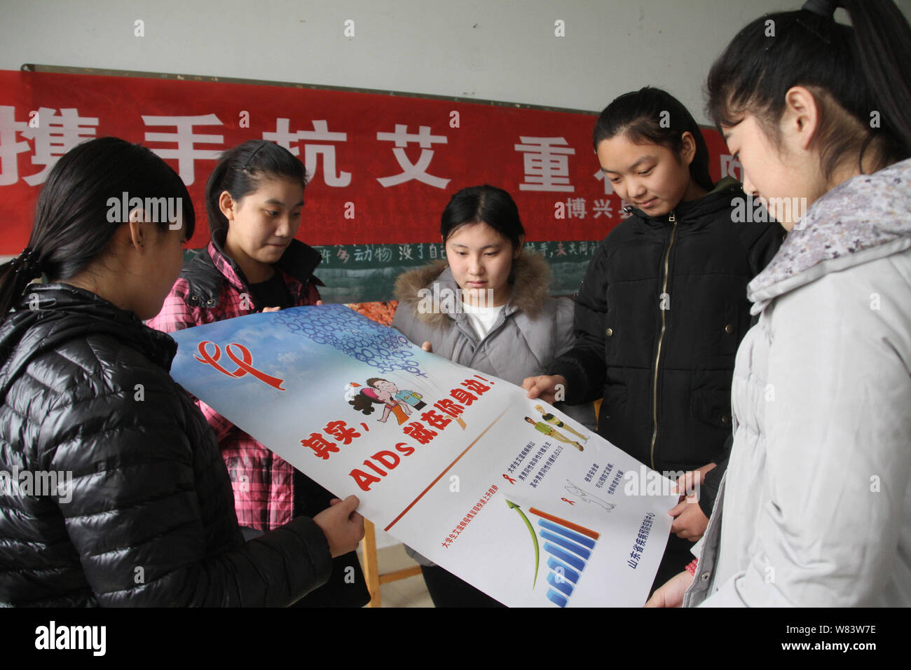 Chinesische Schüler lesen ein Plakat Propaganda Vorbeugung von HIV und AIDS an einer beruflichen Schule in Boxen County, Binzhou Stadt, Stockfoto