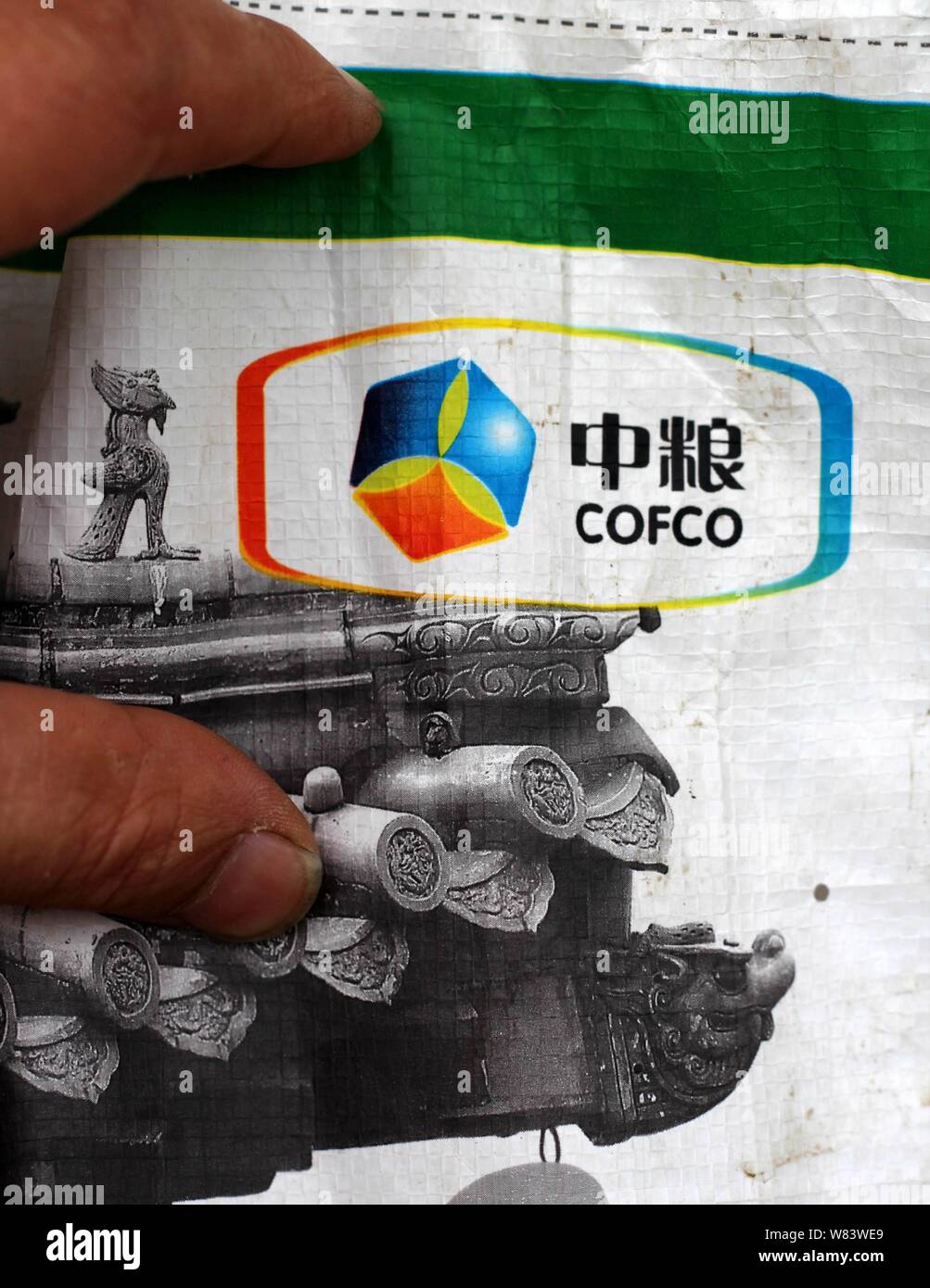 ---- Ein Kunde schaut auf ein Logo von COFCO (China National Getreide, Öle und Lebensmittel Corporation) auf einem Sack Reis in einem Supermarkt in Chongqing, Chi Stockfoto