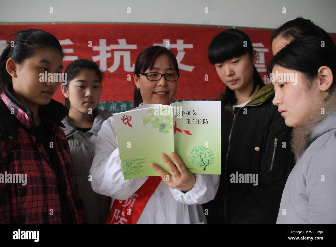 Ein chinesischer medizinischer Arbeiter propagandizes Vorbeugung von HIV und AIDS zu den weiblichen Studierenden an einer beruflichen Schule in Boxen County, Binzhou c Stockfoto
