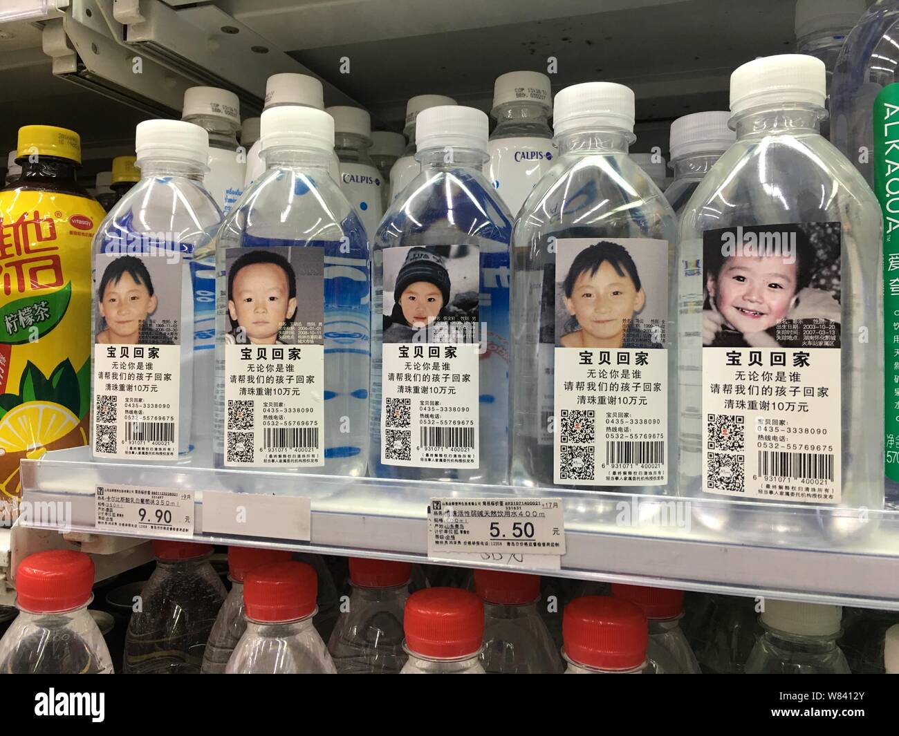Flaschen drining Wasser mit Fotos und persönlichen Daten der fehlenden Zicklein gekennzeichnet sind für den Verkauf an einen Verbrauchermarkt in Qingdao ciy, East China" Stockfoto