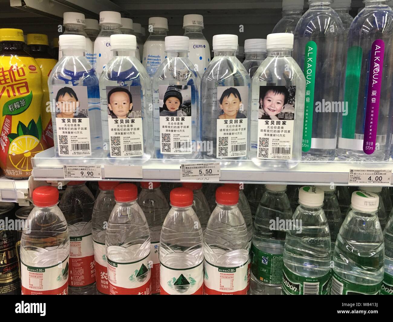Flaschen drining Wasser mit Fotos und persönlichen Daten der fehlenden Zicklein gekennzeichnet sind für den Verkauf an einen Verbrauchermarkt in Qingdao ciy, East China" Stockfoto