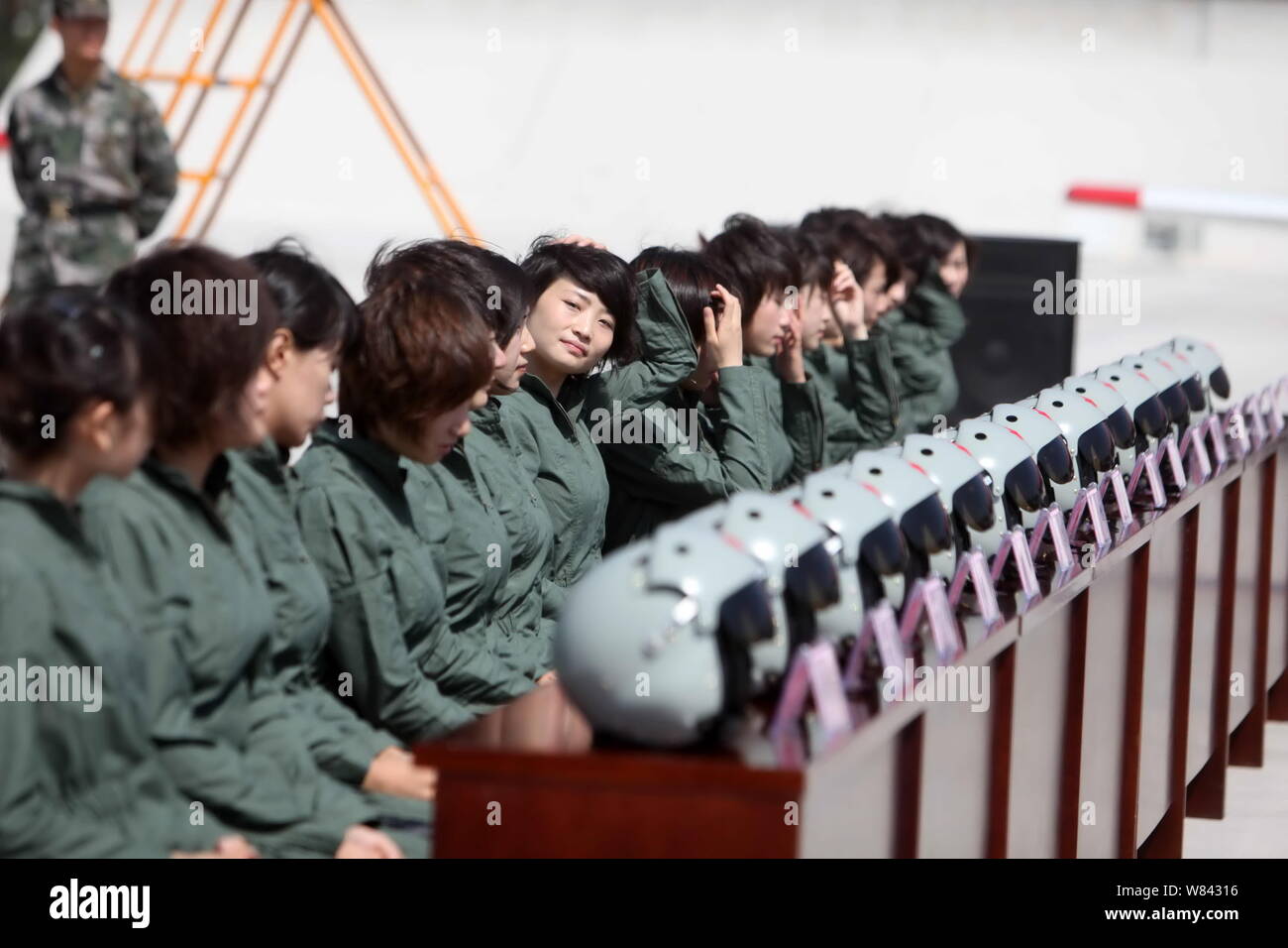 ---- Female Chinese fighter Jet Pilot Yu Xu, Mitte, passt Ihr Haar neben anderen weiblichen Piloten während einer neuen Fliegeroverall Versand Zeremonie an einem Stockfoto