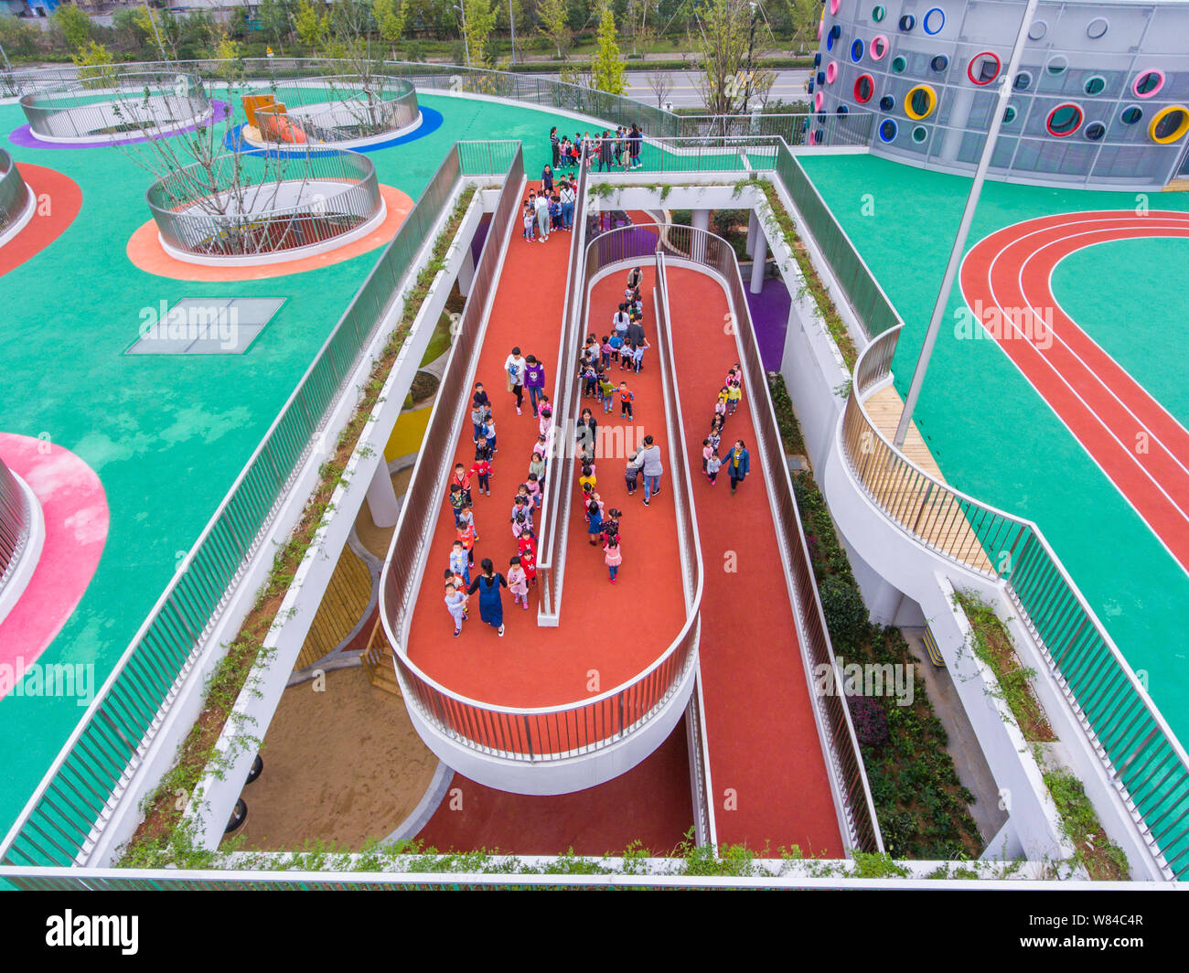 Chinesische Kinder gehen Sie in Richtung Running Tracks auf dem Dach eines Gebäudes in einem neu eröffneten Kindergarten in Huzhou, im Osten der chinesischen Provinz Zhejiang, 17. Stockfoto