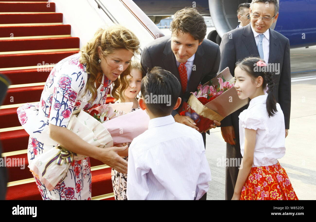 Kanadische Premierminister Justin Trudeau, Mitte, und seine Frau Sophie Gregoire, links, halten Blumensträuße nach Gepäckablagefächer über den Sitzen, mit ihrer Tochter Ella - Stockfoto