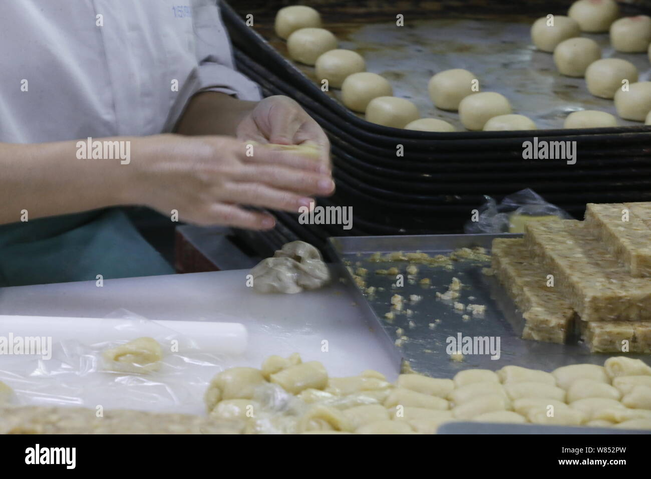 Ein chinesischer Arbeiter bereitet den Teig mooncakes für die kommenden Mid-Autumn Festival in einem Lebensmittel verarbeitenden Betrieb von Peking Daoxiangcun Lebensmittel zu machen Stockfoto