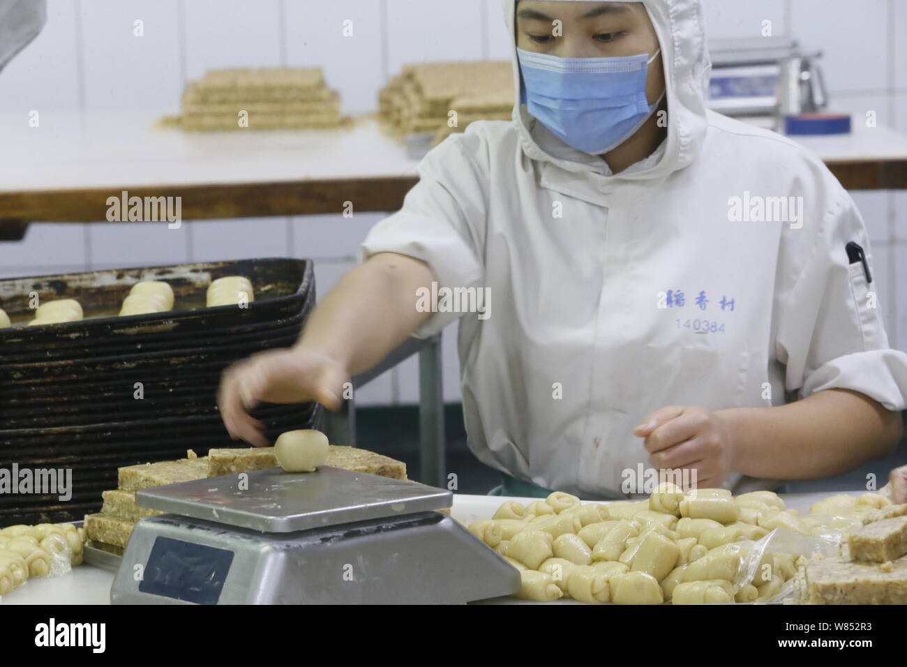 Ein chinesischer Arbeiter wiegt Teig von Mooncakes in einem Lebensmittel verarbeitenden Betrieb von Peking Daoxiangcun Lebensmittel Co., Ltd., Peking, China, 4. September 2016. Ein Stockfoto