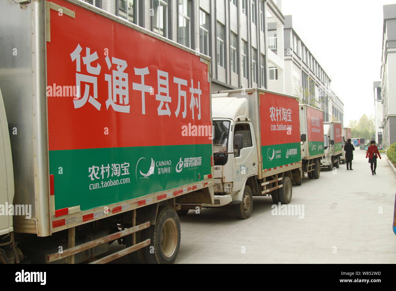 ---- Vans von Alibaba Logistikdienstleistungen Cainiao Netz unterstützt werden an einer Tankstelle von cun.taobao.com, Chinesische e-commerce Alibaba ist geparkt Stockfoto