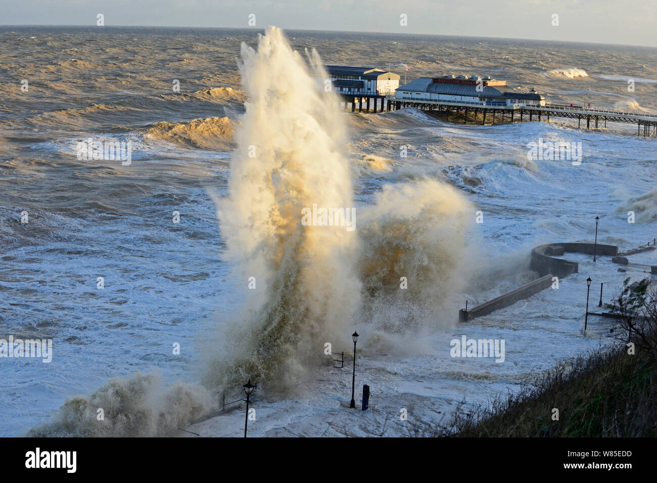 Hohe Wellen peitschen Cromer Strandpromenade und Seebrücke während der Sturmflut., Norfolk, England, UK. Dezember 2013. Stockfoto