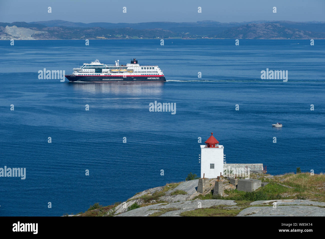 Buchenberg Leuchtturm und Kreuzfahrtschiff, Fjord, Norwegen, Juli. Stockfoto