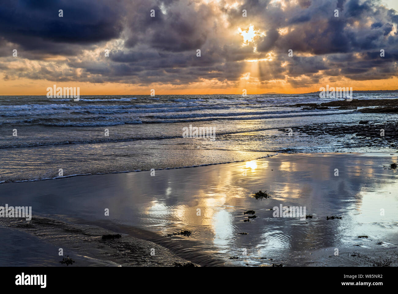 Einen schönen Abend Sonnenuntergang an der Dunraven Bay an der Glamorgan Heritage Coast, South Wales, mit herrlichem cloud Reflexionen im nassen Sand. Stockfoto