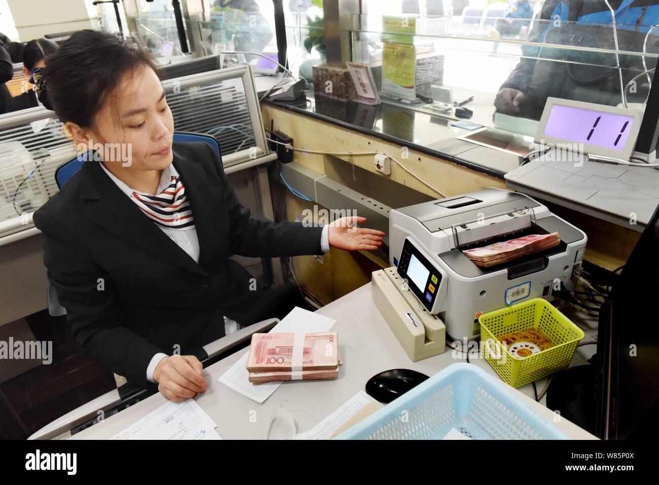 ---- Eine chinesische Angestellte verwendet eine Cash - Zählmaschine RMB (Renminbi) Yuan Banknoten bei einer Bank in Lanzhou Stadt zu zählen, der East China Jiangsu provin Stockfoto
