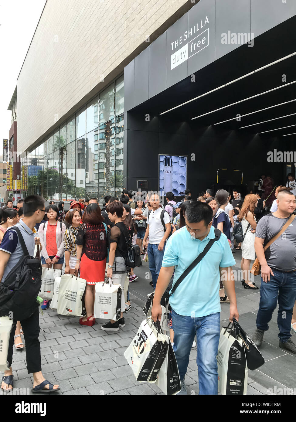 Chinesische Touristen warten draußen einen Duty Free Shop nach dem Einkaufen in Jeju, Südkorea, 27. August 2016. Mit der wachsenden Zahl der Mittelklasse, Ch Stockfoto