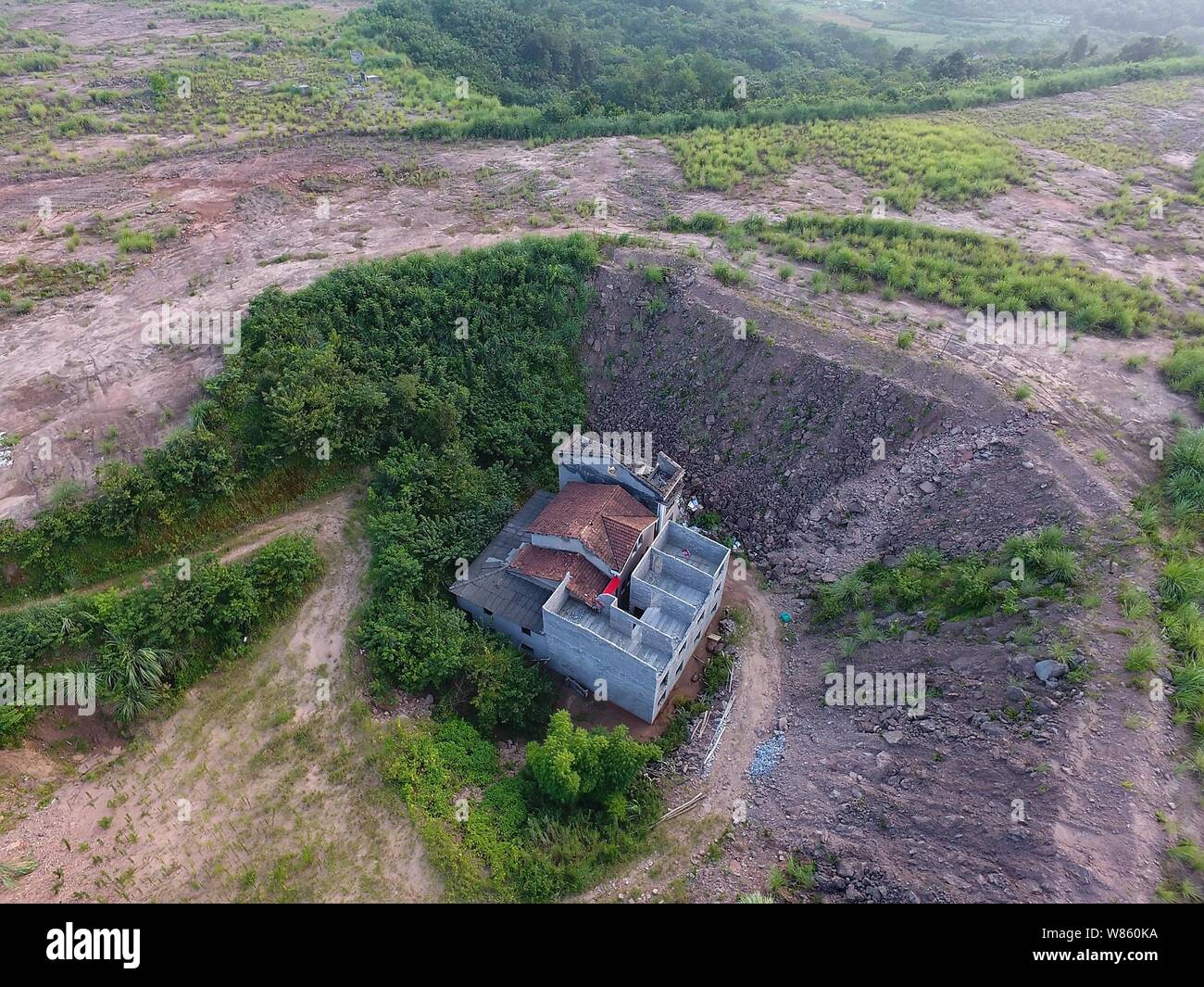 Ein Nagel Haus, dessen Besitzer weigerte sich wegen Streitigkeiten über Entschädigung details zu verschieben ist in einer Grube auf der Baustelle eines industriellen isoliert Stockfoto