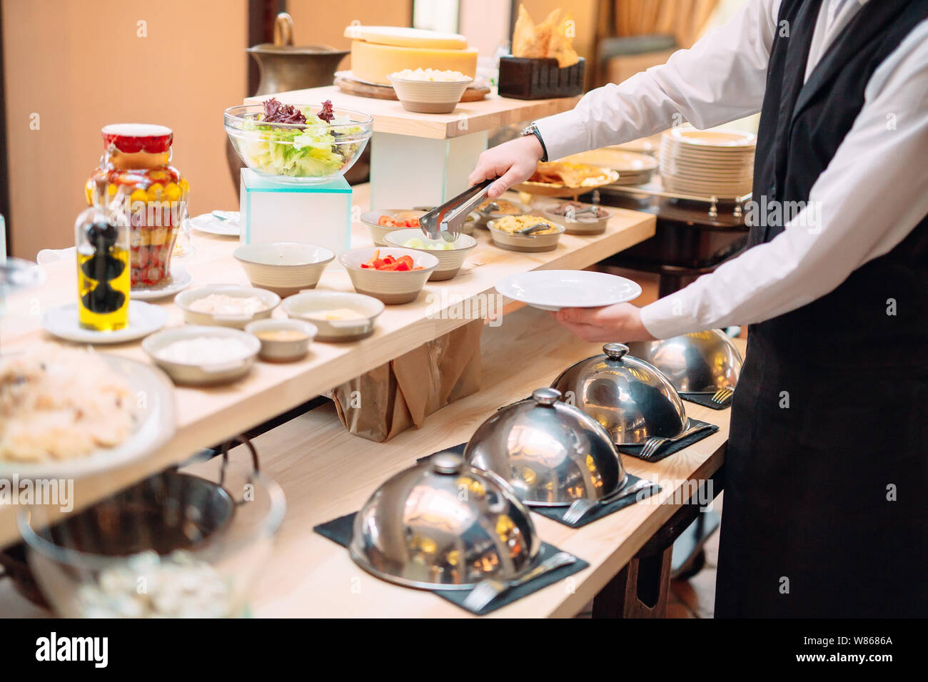 Sauerkraut. Das Frühstück im Hotel oder im Restaurant. Der Kellner sieht das Sauerkraut in die Schüssel. Stockfoto