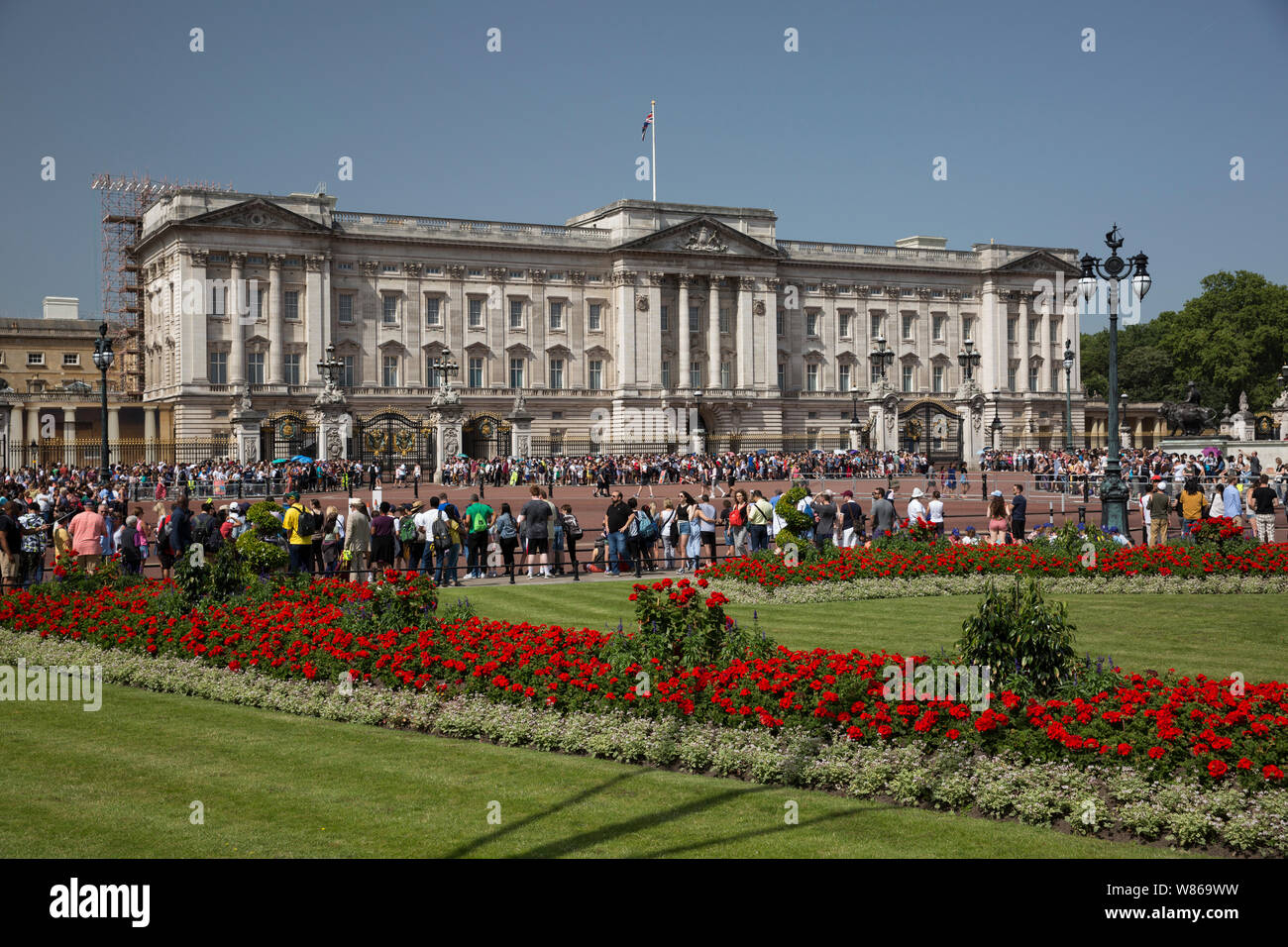 Buckingham Palace an einem Juni Sommertag, als die Massen von Touristen vor den Toren drängen, um die Wachen hinter den hohen Toren zu beobachten, London, Großbritannien Stockfoto