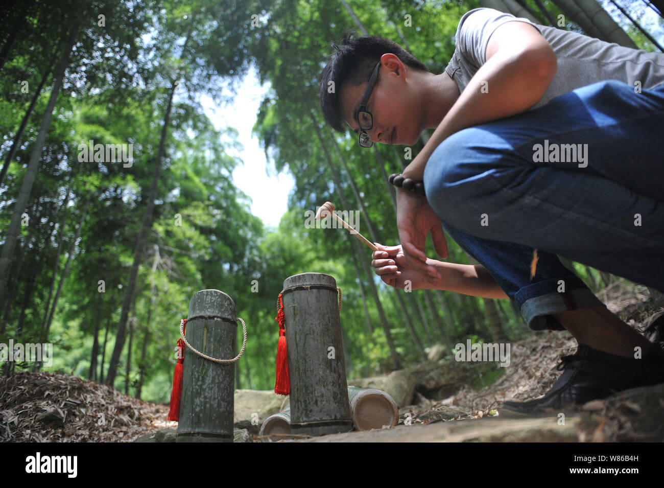 Ein chinesischer Arbeiter mit einem Holzhammer eine gemeinsame eines  Knotens von Bambus mit Reis gebraut Schnaps oder Wein in einem Bambuswald  in Baishuijian vi gefllt zu klopfen Stockfotografie - Alamy