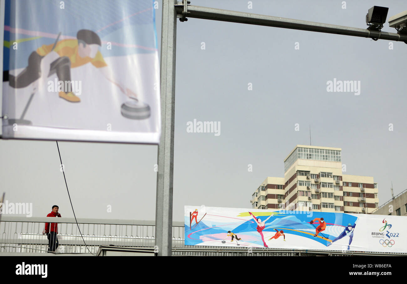---- Ein Fußgänger geht Vergangenheit ein Banner der Beijing 2022 Olympischen Winterspiele auf einer Fußgängerbrücke in Peking, China, 19. März 2015. China führt s Stockfoto