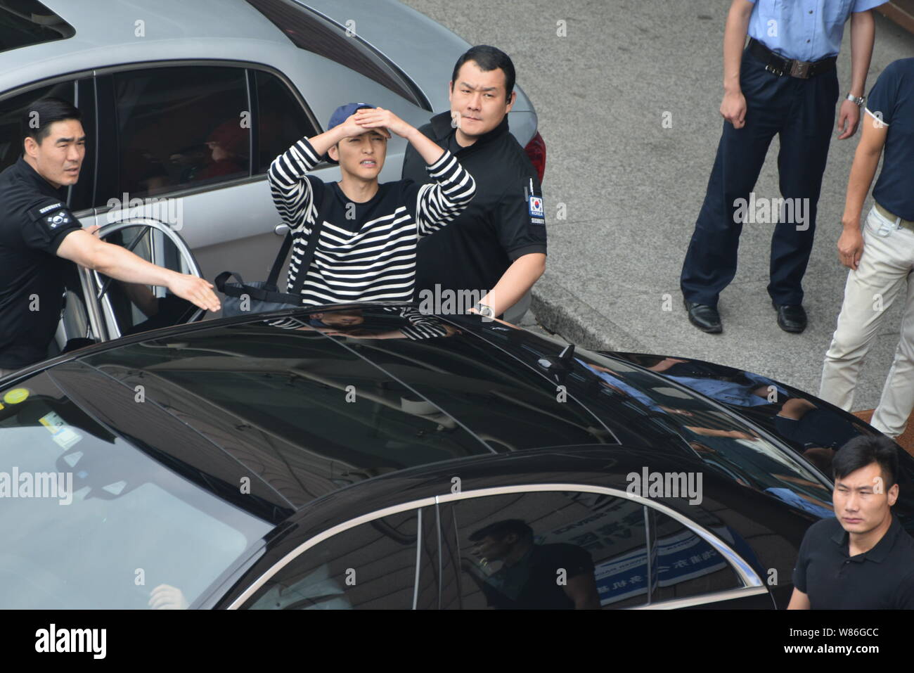 Koreanische Schauspieler Song Joong-ki, Mitte, reagiert, als er den internationalen Flughafen Shanghai Pudong verlässt nach der Ankunft in Shanghai, China, 15. Juli 201 Stockfoto