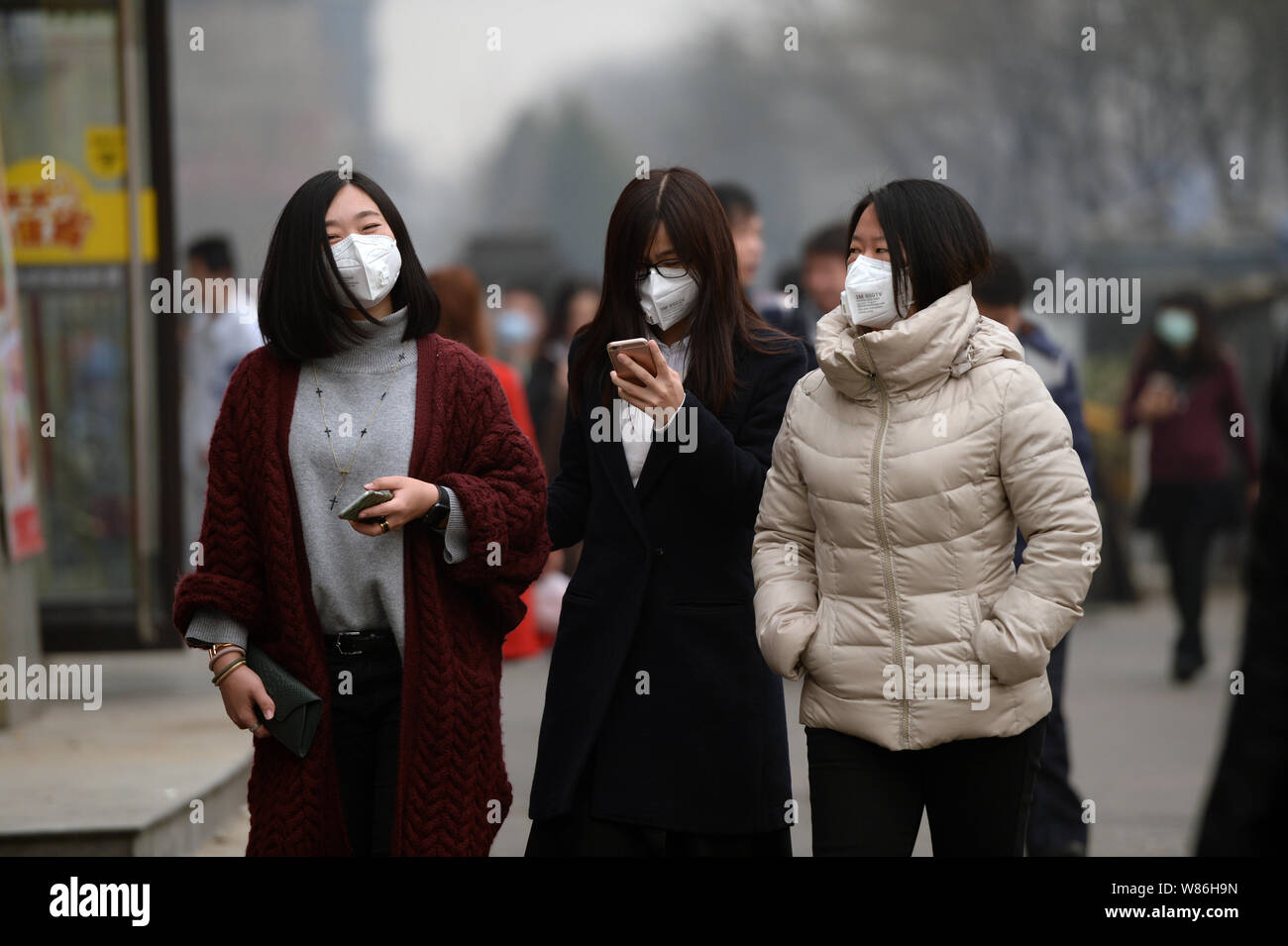 ---- Fußgänger tragen Gesichtsmasken zu Fuß auf der Straße in schweren Smog in Peking, China, 4. März 2016. Chinesischen Einwohner leben unter Smog - belched Stockfoto