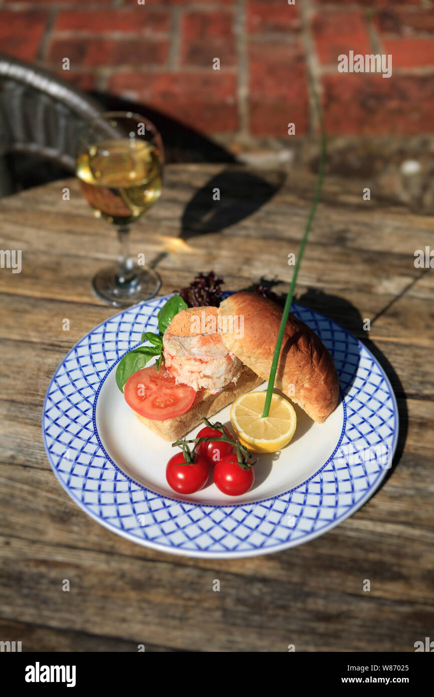 Frische Krabben Sandwich mit Tomate, Salat und ein Glas Wein im Freien Stockfoto