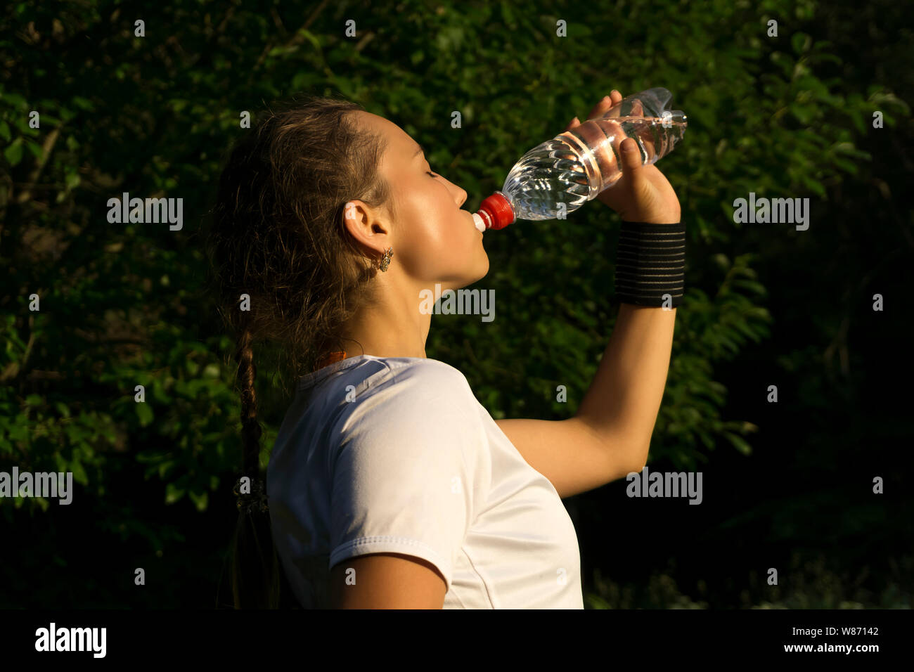 Mädchen nach Sport im Park Durst Getränke Wasser aus der Flasche. Stockfoto