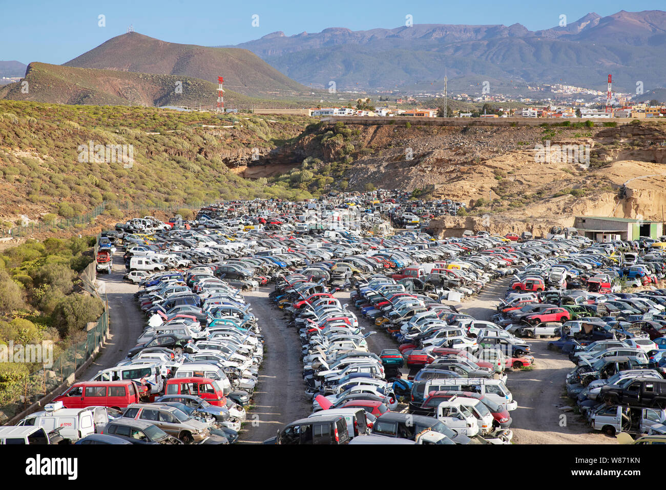 Gestapelt recycelt Autos, alte abgestürzte Fahrzeuge für Teile oder als Schrott auf einem Schrottplatz oder einer Recyclinganlage im Süden von Teneriffa, Spanien Stockfoto