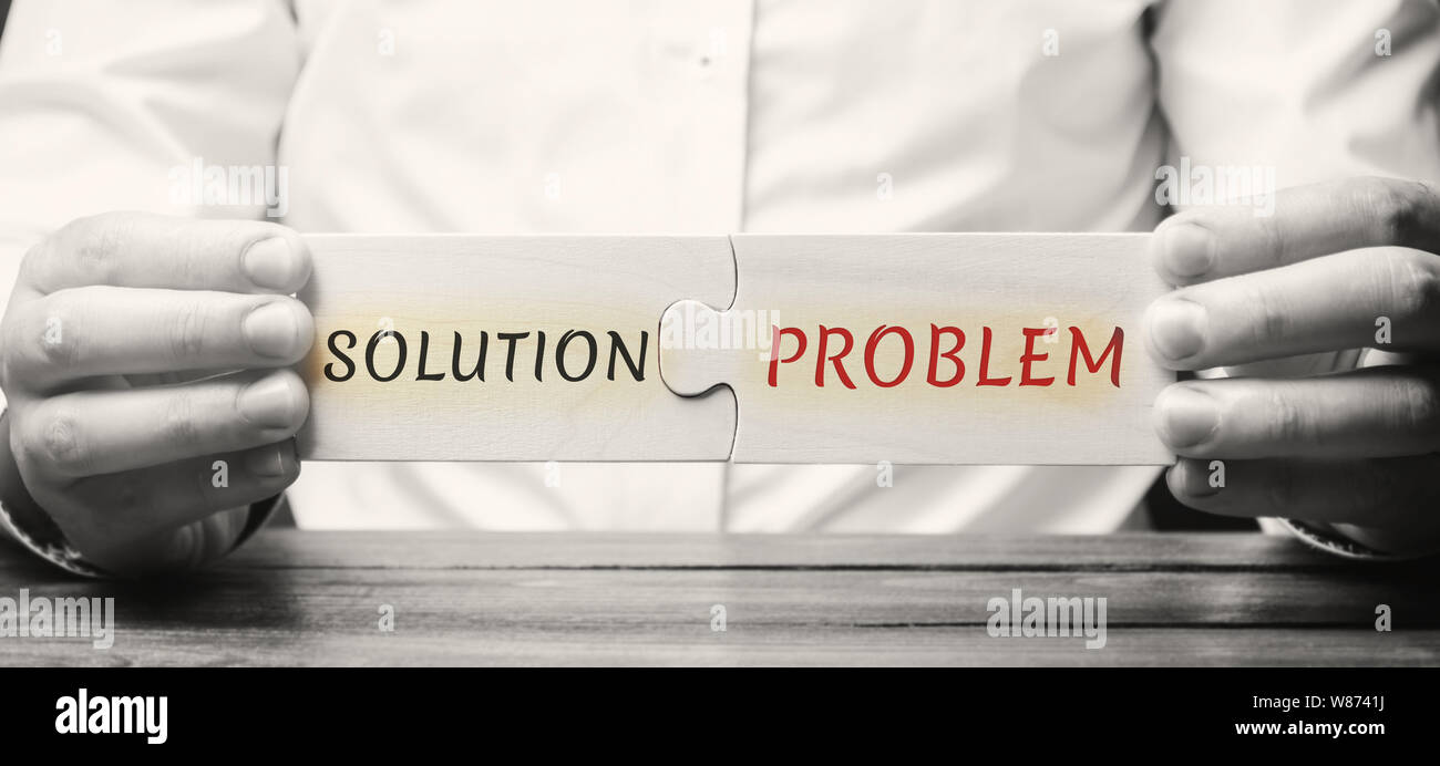 Geschäftsmann sammelt Puzzles aus Holz mit dem Wort Lösung Problem. Eine Strategie zur Überwindung der Probleme und Schwierigkeiten. Konzept die Motivation. Stockfoto