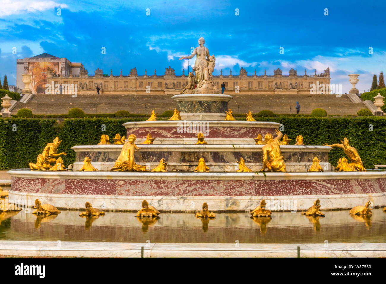 Tolle Nahansicht der Latonabrunnen (Bassin de Latone) in den Gärten von Versailles mit dem Schloss im Hintergrund. Auf der obersten Stufe ist ein... Stockfoto