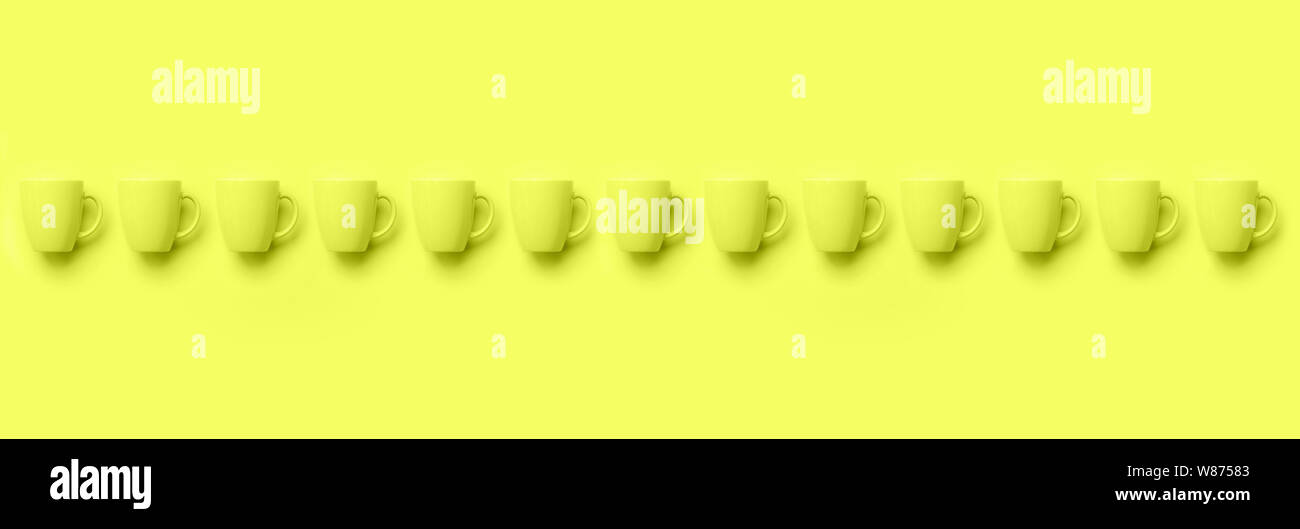 Zeile mit Cups über Gelb neon Hintergrund. Geburtstag Feier, baby Konzept Dusche. Monochrome Farben Muster. Banner. Minimalistisches Design Stockfoto