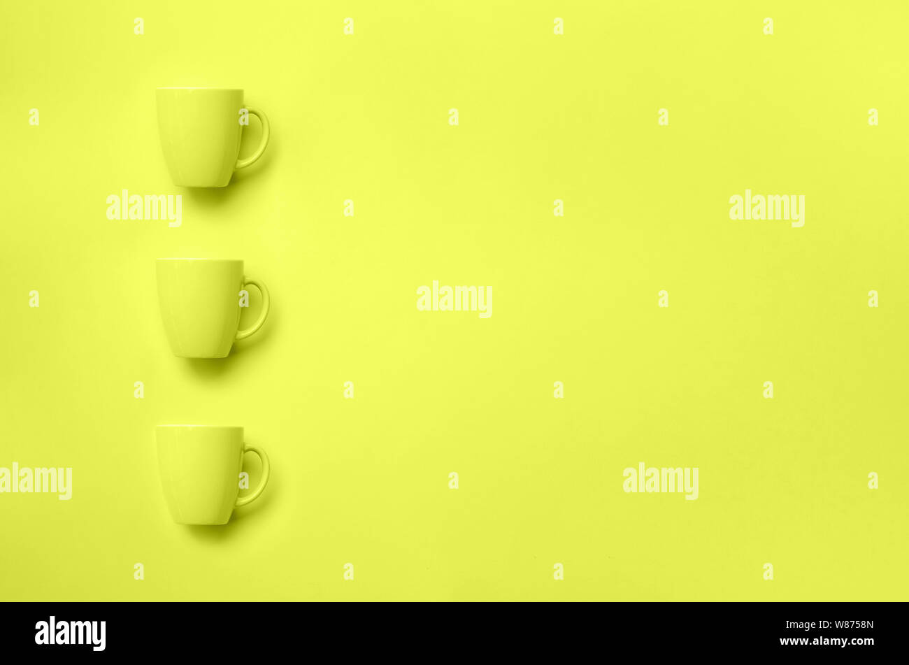 Zeile mit Cups über Gelb neon Hintergrund. Geburtstag Feier, baby Konzept Dusche. Monochrome Farben Muster. Banner. Minimalistisches Design Stockfoto