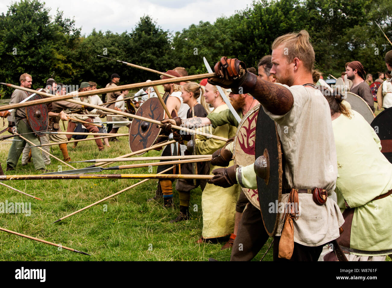 Viking Krieger kämpfen auf dem Schlachtfeld im Ribe Viking Center in Lostrupholm in der Nähe von Ribe, Dänemark. Rund 200 Krieger, sowohl Männer als auch Frauen, nehmen die dramatische und lebensechte Schlacht, die mit modernen Waffen gekämpft wird und auf der Nordischen 9. Jahrhundert Regnar Lodborg Viking Saga basiert. Ribe Viking Center ist eine Erfahrung, die sich in der Nähe des historischen Wikingerdorf, Ribe gelegen, im südlichen Teil von dem dänischen Festland. Stockfoto