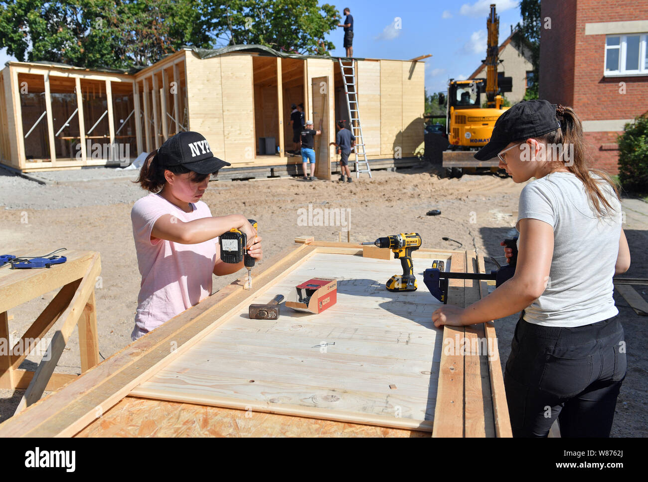 08. August 2019, Sachsen-Anhalt, Dessau-Roßlau: Studierende der Universität Kassel bauen ein Holzhaus im Bauhaus Dessau-Törten, die Pläne des Bauhaus Architekten Ludwig Hilberseimer inspiriert. Der Flachbau in unmittelbarer Nähe der Arkaden der bekannten Häuser sollen die ursprünglichen Pläne der Hilberseimer und Bauhausdirektor Hannes Meyer erinnern. Foto: Hendrik Schmidt/dpa-Zentralbild/ZB Stockfoto