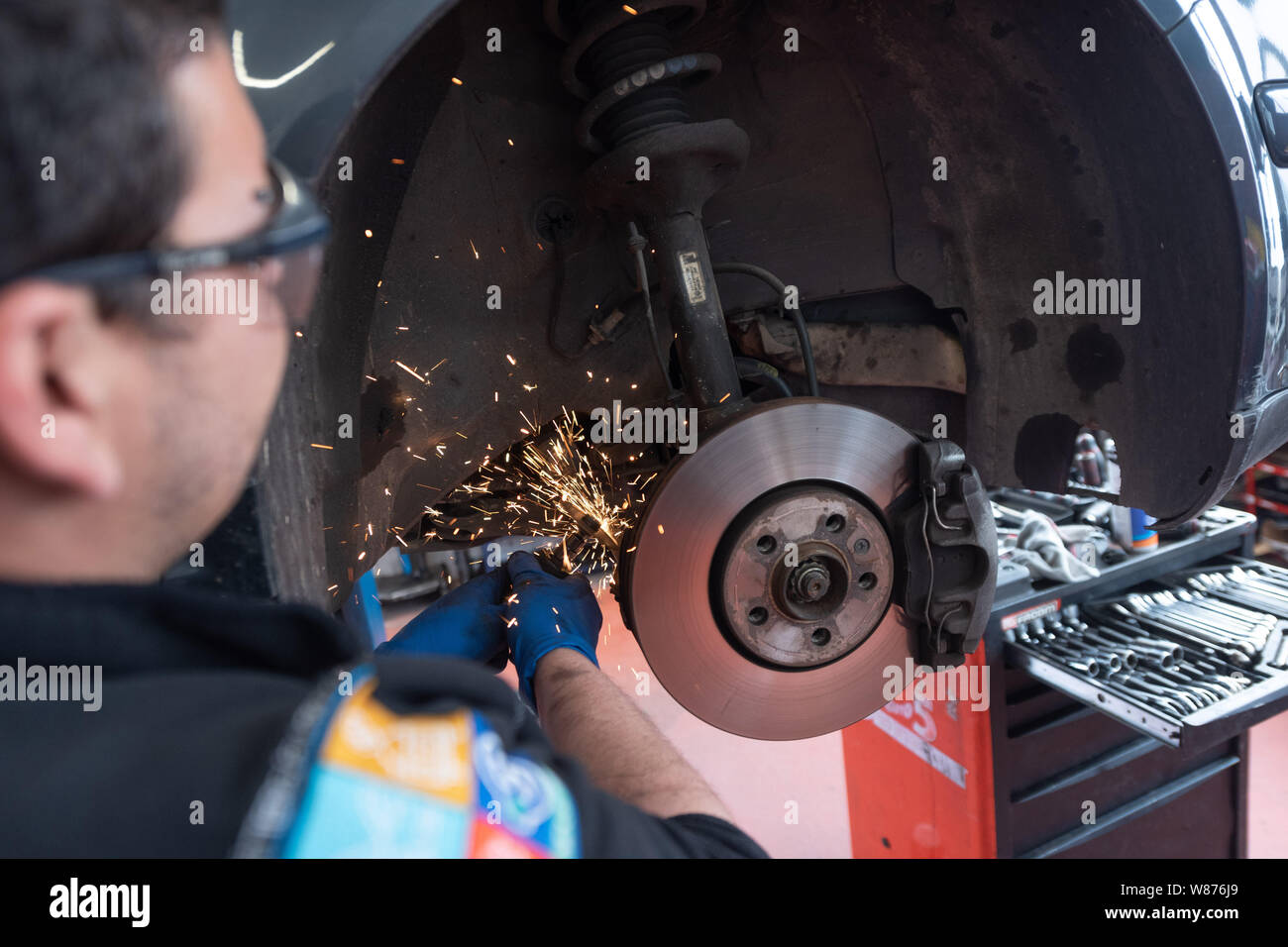 Garage: KFZ-Mechanik. Mechaniker arbeiten an Bremsscheiben und Bremsbeläge von einem Auto. Stockfoto