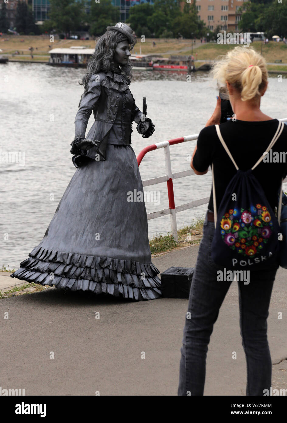 Krakau. Polen. Street Performer in altmodischen Kostüm an der Weichsel bank Boulevard. Vorbei an Tourist, der Snapshot mit Handy. Stockfoto